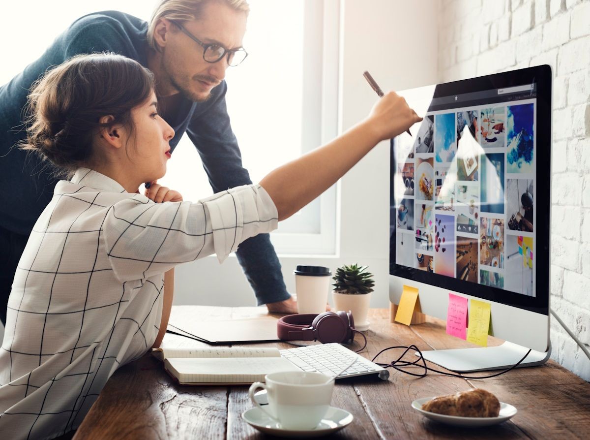 workers consulting on website screen