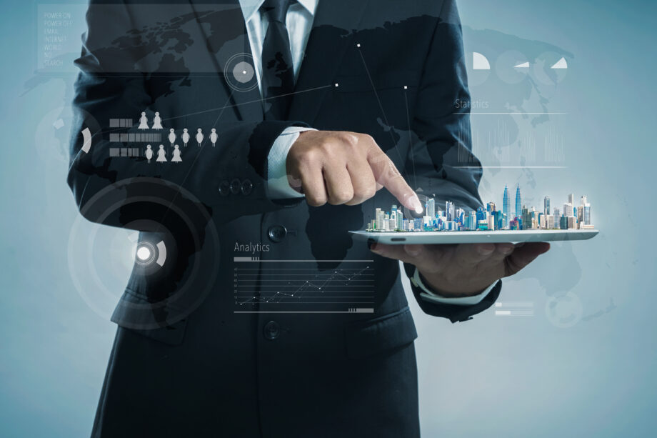 A man in a suit interacts with a digital interface featuring city models, analytics, and global maps, suggesting technology and data visualization.