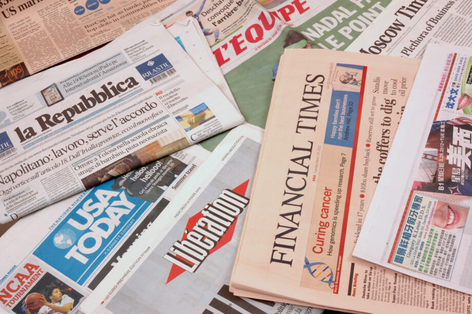 A collection of international newspapers laid out, featuring headlines from La Repubblica, USA Today, Financial Times, and others.